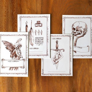 Puede incluir: Cuatro tarjetas blancas con ilustraciones de tinta marr&oacute;n y el texto "Ex Libris" en cada tarjeta. Las ilustraciones incluyen una pluma, un tintero y un alfabeto, una calavera, una daga y un &aacute;ngel.