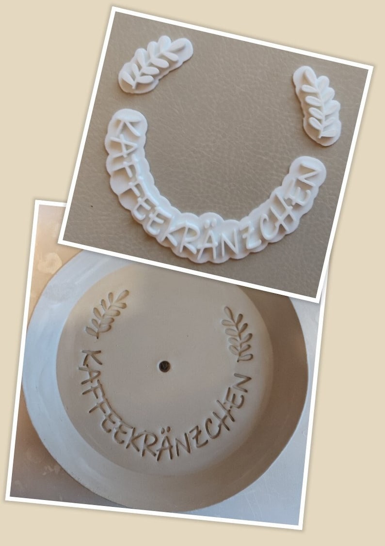 Op de afbeelding: Een witte plastic mal voor het maken van koffiekoeken, met de woorden "Kaffee Kr&auml;nzchen" en twee bladeren.