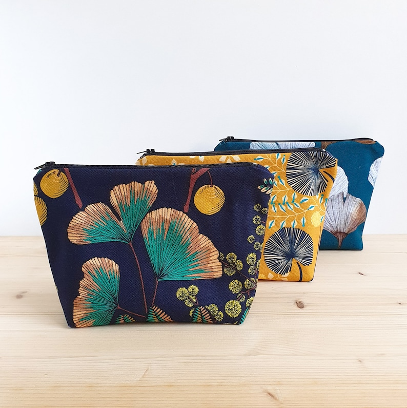 Trousse à maquillage ou trousse de toilette à motifs ginkgo ou feuilles, sur fond bleu marine, bleu pétrole ou jaune