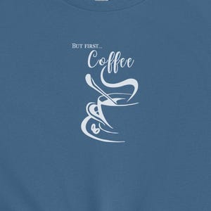 May include: A blue t-shirt with the text "But first... Coffee" and a stylized image of a coffee cup with steam rising from it.