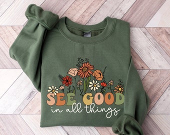 May include: A green sweatshirt with a floral design and the text "See good in all things".