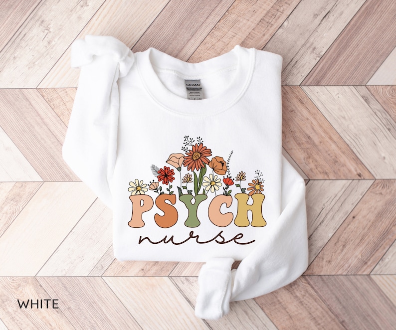 May include: White sweatshirt with a floral design and the text "PSYCH nurse" in colorful retro letters.