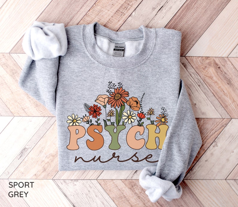 May include: A gray sweatshirt with the text "PSYCH nurse" in colorful letters with a floral design behind the text.