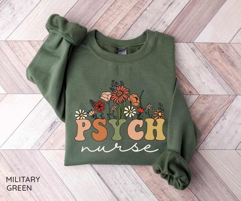 May include: A green sweatshirt with the text "PSYCH nurse" in colorful letters surrounded by a floral design.