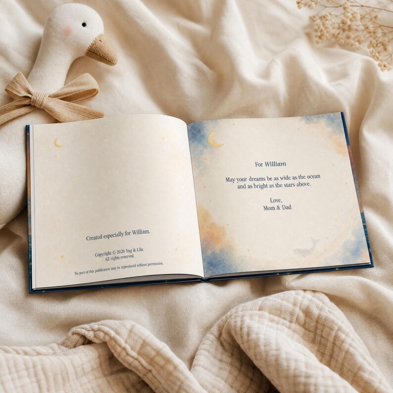 May include: An open hardcover book with cream-colored pages featuring blue and orange watercolor accents. The text reads: For William, May your dreams be as wide as the ocean and as bright as the stars above. Love, Mom & Dad. Created especially for William.
