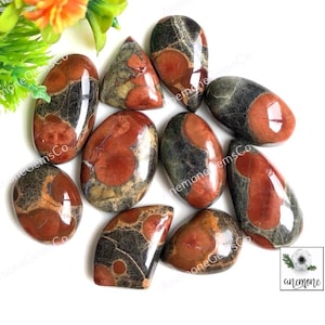 May include: A collection of ten polished orbicular jasper stones featuring a distinct pattern of dark charcoal gray and deep reddish-brown circular inclusions. The stones are smooth, glossy, and vary in shape, including oval, teardrop, and irregular forms.