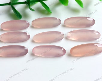 May include: Ten oval-shaped, pale pink gemstone cabochons. The cabochons are smooth and polished, with a translucent appearance.