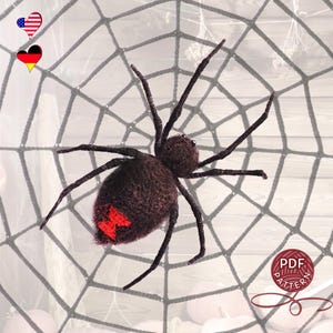 Puede incluir: Una araña marrón oscuro hecha a mano con patas largas y una marca de reloj de arena roja en su abdomen, sobre una telaraña gris. La araña es el punto focal, con una apariencia texturizada. Un icono de patrón PDF está en la esquina inferior derecha.