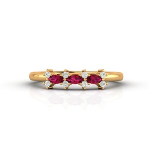 Peut inclure: Une bague en or ornée d'une série de pierres précieuses rouges en forme de marquise, entrecoupées de groupes de petites pierres précieuses blanches rondes. La bague a un fin anneau poli.