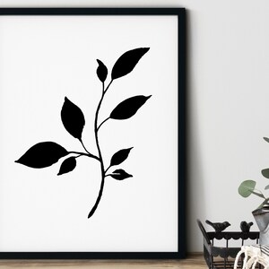 Pode incluir: Silhueta preta e branca de um ramo frondoso com cinco folhas. A imagem est&aacute; emoldurada em uma moldura preta e sobre um fundo branco.
