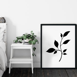 Pode incluir: Impress&atilde;o art&iacute;stica minimalista em preto e branco com uma silhueta estilizada de um ramo frondoso. A impress&atilde;o &eacute; emoldurada em uma moldura preta e &eacute; exibida em uma parede branca.