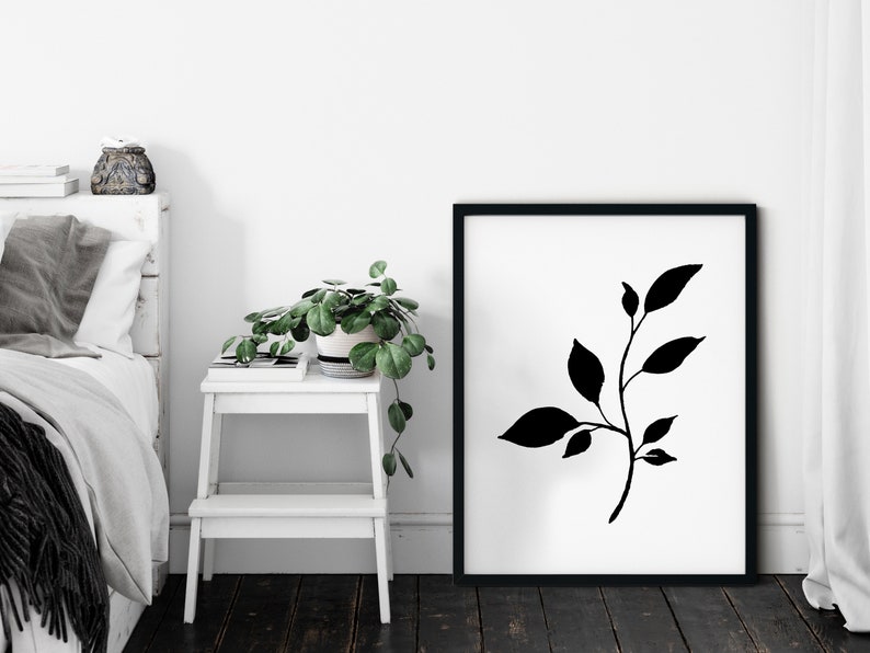 Pode incluir: Impress&atilde;o art&iacute;stica minimalista em preto e branco com uma silhueta estilizada de um ramo frondoso. A impress&atilde;o &eacute; emoldurada em uma moldura preta e &eacute; exibida em uma parede branca.