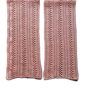 May include: Two pink crocheted rectangular pieces with a lacy pattern.