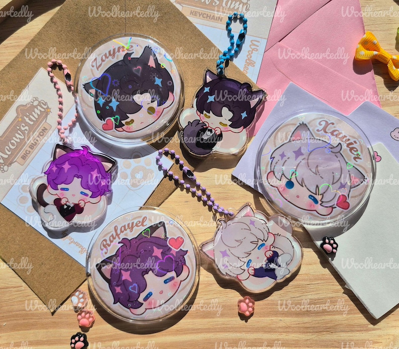 Pode incluir: Um conjunto de tr&ecirc;s bot&otilde;es redondos e tr&ecirc;s pingentes de acr&iacute;lico com personagens de estilo anime com orelhas de gato. Os personagens chamados Zayne, Xavier e Rafayel apresentam cabelos coloridos, detalhes hologr&aacute;ficos e pequenos cora&ccedil;&otilde;es.
