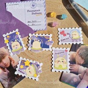 May include: A set of ten colorful stickers featuring cartoon aliens in spaceships. The stickers are shaped like postage stamps and have different phrases, including "Love ya", "Huggies", and "Mine".