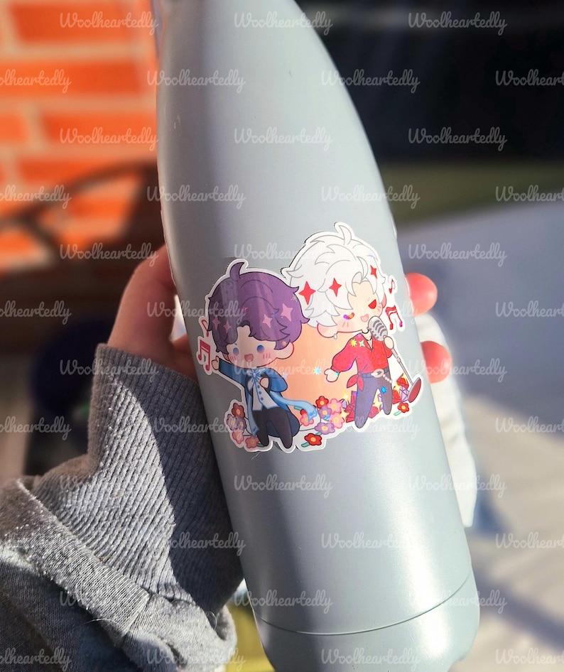 May include: A light gray water bottle with a sticker featuring two cartoon characters. One character has purple hair and the other has white hair. The sticker has a floral design and musical notes.