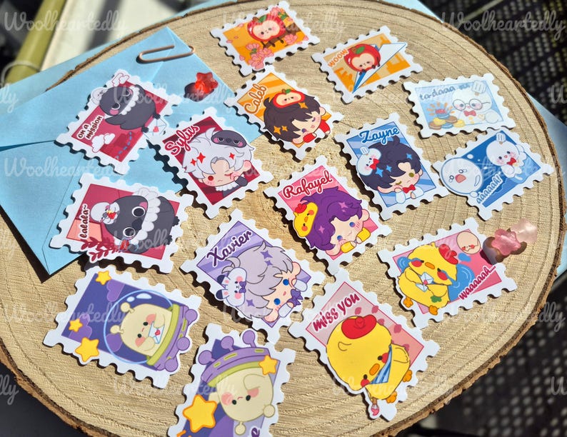 May include: A set of 15 colorful stickers featuring various cartoon characters and designs. The stickers are shaped like postage stamps and have a scalloped edge. Some of the characters include a penguin, a chick, a bunny, and a person with purple hair. The stickers have text on them, including "Caleb", "Sylus", "Zayne", "Rafayel", "Xavier", "to-doaa", "Waaaaak", "miss you", and "Calala".