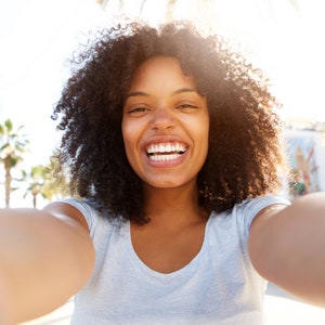 beautiful woman smiling to the camera in sunshine