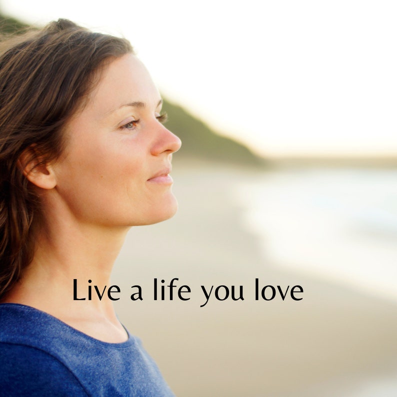 May include: A woman with long brown hair looks off to the side with a thoughtful expression. She is wearing a blue shirt and the background is blurred. The text "Live a life you love" is in the foreground.