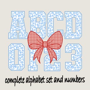 May include: A complete alphabet set and numbers design. The letters and numbers are light blue with a leopard print pattern. A red and white gingham bow is centered between the letters and numbers. The text "complete alphabet set and numbers" is below.