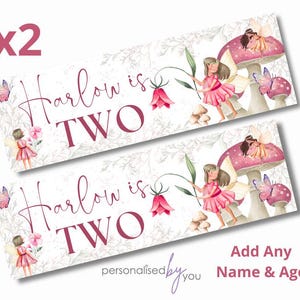 May include: Two personalised banners with the text "Harlow is TWO". The banners feature illustrations of fairies, mushrooms, and butterflies in pink and white. The text "Add Any Name & Age" is also included.