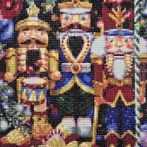 May include: A close-up of a colorful diamond painting depicting three nutcracker figurines. The nutcracker in the center is wearing a blue and gold uniform with a crown. The nutcracker on the left is playing a drum and the nutcracker on the right is holding a staff.