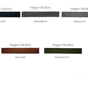 May include: Five fabric swatches with the text "Dapper Dachery" above each swatch. The swatches are black, black with white polka dots, dark gray, brown, and dark green.