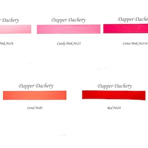 May include: Five swatches of Dapper Dachery fabric in different shades of pink and red. The swatches are labeled with the color name and number: Baby Pink No24, Candy Pink No25, Cerise Pink No114, Coral No83, and Red No28.