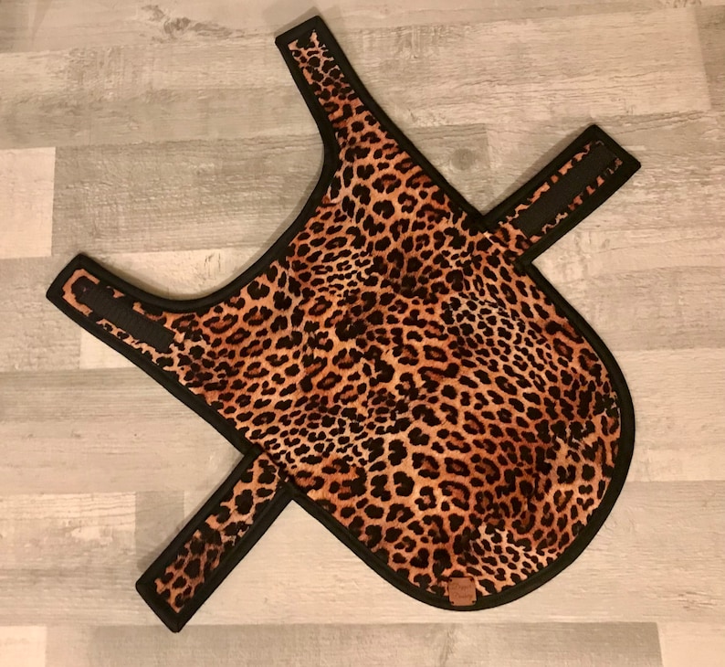 Puede incluir: Un abrigo para perros con estampado de leopardo, con ribetes negros y correas ajustables. El abrigo presenta un patr&oacute;n de manchas marrones y negras. El abrigo est&aacute; dise&ntilde;ado para un ajuste c&oacute;modo.
