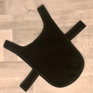Puede incluir: Un abrigo negro para perros con correas ajustables. El abrigo est&aacute; hecho de un material suave y duradero y est&aacute; dise&ntilde;ado para brindar calidez y protecci&oacute;n a los perros. El abrigo tiene una forma redondeada y est&aacute; dise&ntilde;ado para adaptarse c&oacute;modamente a la espalda de un perro.