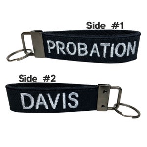 May include: Black key chain with a silver metal ring and clasp. The key chain has two sides, one side says "PROBATION" and the other side says "DAVIS".