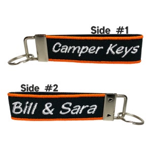 May include: Black and orange key chain with the text "Camper Keys" on one side and "Bill & Sara" on the other side.
