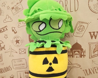 May include: A green and yellow plush toy with a radiation symbol on its chest. The toy is wearing a green hat and has a striped pattern on its legs.
