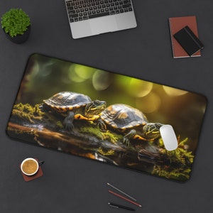 May include: Rectangular mouse pad featuring two turtles on a moss-covered log. The turtles have dark shells with yellow markings. The background is a blurred green and gold, with a black border.