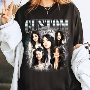 May include: Black t-shirt with a silver graphic of the word "CUSTOM" with the word "Text" underneath. The graphic is surrounded by images of five women.