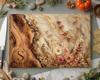 May include: A rectangular serving board featuring a natural wood edge on the left side with a laser-engraved letter S inside a wreath. The right side is made of a smooth, cream-colored resin embedded with various dried flowers and foliage.