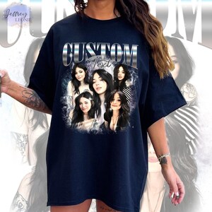 May include: A navy blue oversized t-shirt with a graphic print of five women's faces. The text "CUSTOM Text" is printed in silver above the graphic.