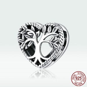 May include: A silver charm in the shape of a heart with a tree of life design. The charm is detailed with intricate branches and leaves. The charm is made of sterling silver and has a 925 stamp.