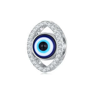 May include: Silver charm with a blue evil eye design surrounded by clear cubic zirconia stones.