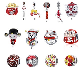 May include: A set of 14 silver charm beads with red and gold enamel detailing. The charms feature Chinese New Year symbols like a lucky cat, a lion dance, and a red envelope. The charms are perfect for adding a touch of Chinese New Year cheer to your jewelry.