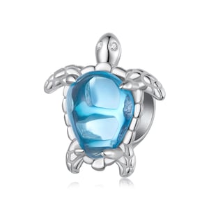 May include: Silver charm featuring a blue crystal turtle with clear crystal accents.