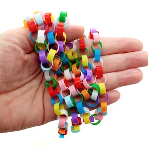 May include: A colorful chain made of linked plastic rings in various colors, including red, orange, yellow, green, blue, purple, and white.