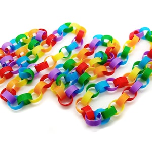 May include: A rainbow coloured paper chain made of interlocking circles. The chain is made of red, orange, yellow, green, blue, indigo, and violet paper.
