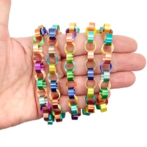 May include: Six colourful metal chains made of linked rings. Each chain is a different colour combination of green, blue, yellow, orange, and purple.