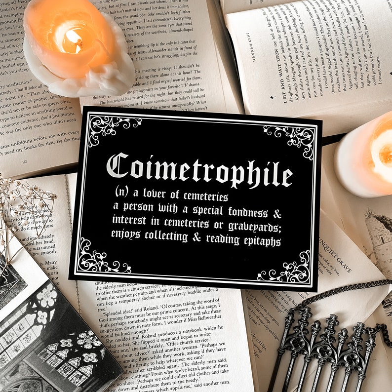 Puede incluir: Impresi&oacute;n en blanco y negro con una definici&oacute;n en fuente g&oacute;tica de la palabra "Coimetrophile", que significa "amante de los cementerios". La impresi&oacute;n est&aacute; sobre un fondo negro con letras blancas y un borde decorativo.