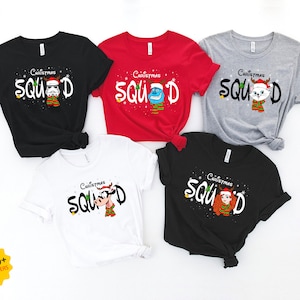 May include: Set of five Christmas themed t-shirts in black, red, gray, white, and black. Each shirt features a different character from the Christmas Squad with the text "Christmas Squad" on each shirt.