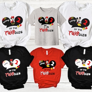 K&ouml;nnte beinhalten: Satz mit sechs T-Shirts mit einem Mickey Mouse und Minnie Mouse Design mit dem Text "Of the Twodles" und "I'm one of the Twodles". Die Shirts sind in Schwarz, Wei&szlig;, Rot und Grau.