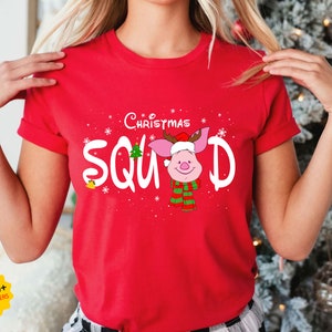 May include: Red t-shirt with a white graphic of a pig wearing a Santa hat and the text "The Christmas Squad".