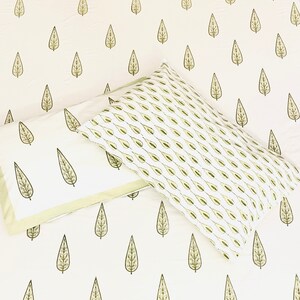 May include: Two white pillowcases with a green leaf pattern. The pillowcases are made of cotton and have a soft, comfortable feel.