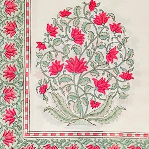 K&ouml;nnte beinhalten: Wei&szlig;er Stoff mit floralem Muster. Das Design zeigt gro&szlig;e, leuchtend rosa Bl&uuml;ten mit gr&uuml;nen Bl&auml;ttern und Stielen. Ein Rand mit einem &auml;hnlichen Blumenmotiv und einem rosa und rot gestreiften Akzent umrahmt das Hauptdesign.
